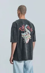 Remera negra con efecto acid wash, corte holgado y estampa frontal con diseño alusivo a Disney.