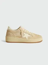 Zapatillas deportivas Golden Goose modelo Ball Star, color beige claro, con estrella lateral en color crema y suela de goma color caramelo. Presentan un aspecto desgastado intencional y texto grabado en el lateral.