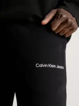 Pantalón de chándal negro confeccionado en 100% algodón regenerativo, con cintura elástica y puños elásticos.