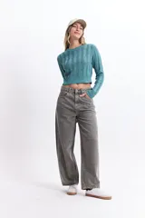 Sweater de punto color mostaza, con diseño de ochos y textura calada. Tiene cuello redondo, mangas largas y terminaciones acanaladas en puños y cintura.