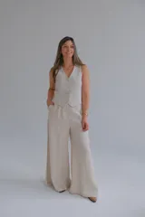 Pantalón de vestir color beige, de corte palazzo y tiro alto.