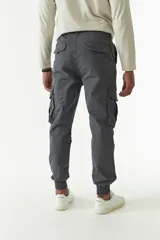 Pantalón cargo gris con puños elásticos, corte regular, bolsillos laterales con solapa y pasacintos.
