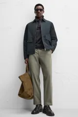 Pantalón chino negro slim fit confeccionado en tejido técnico de secado rápido. Cuenta con bolsillos frontales y traseros de vivo. Cierre frontal con cremallera y botón.