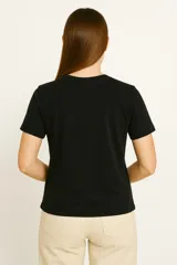 Remera negra de algodón con cuello redondo y estampado de estilo vintage con imágenes de carteles y textos relacionados con el mundo del rodeo.
