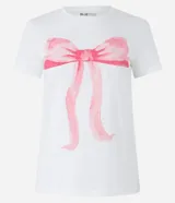 Remera blanca de algodón con cuello redondo y mangas cortas. Presenta una estampa de una moña rosa en el frente.
