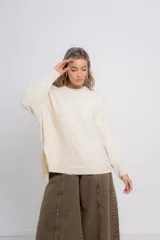 Sweater color crudo de corte holgado, con cuello redondo y terminaciones acanaladas en puños y ruedo.