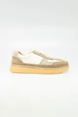 Zapatillas urbanas de cuero color beige, con detalles en blanco y suela de goma color caramelo.