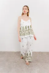 Pantalón blanco con estampado geométrico en azul y marrón, de calce relajado y caída fluida.