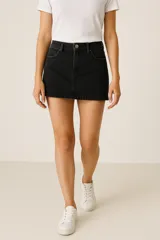 Falda corta de denim color negro, de corte recto, con tiro medio y cinco bolsillos.