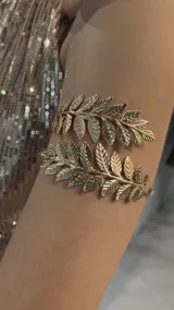 Brazalete dorado con diseño de hojas de laurel.