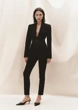 Vestido midi negro de tejido de punto fino, con cuello alto, manga larga, corte ajustado y abertura lateral en el ruedo.