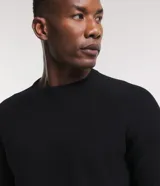 Suéter negro de algodón con cuello redondo y textura de punto.