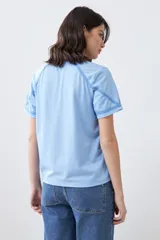 Remera celeste melange de corte clásico, con escote en V y mangas cortas con detalle de costuras en contraste.
