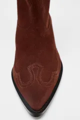 Botín de mujer estilo cowboy color marrón de serraje con puntera fina y tiradores laterales. Tacón de 5 cm.