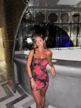Minivestido de microtul con estampado de flores rojas sobre fondo negro.