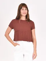 Remera marrón oscuro con corte crop y mangas cortas.