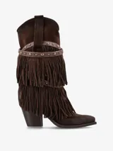 Bota de caña media de gamuza color marrón oscuro, estilo cowboy, con taco medio ancho. Presenta múltiples capas de flecos largos que cubren la caña y una tira decorativa con tachas metálicas alrededor del tobillo.