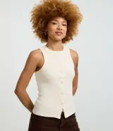 Musculosa color crudo confeccionada en tejido de punto canalé con cuello redondo y abotonadura frontal.