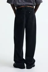 Pantalón de jean negro de corte holgado, con tiro bajo y cinco bolsillos.