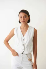 Chaleco denim blanco con botones en la parte delantera y bolsillos frontales.