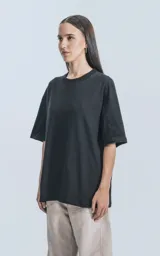 Remera negra de corte crop y calce oversize, con hombros caídos y cuello redondo.
