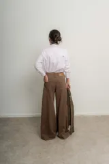 Camisa rosa pálido de algodón con cuello tipo masculino, abotonadura central, manga larga y puños con botones. Presenta canesú y cuello bordado con cadeneta a contratono.