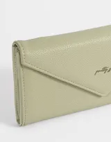 Billetera formato fichero de cuerina color crudo, con estampado de gatos de la suerte, corazones y flores. Tiene solapa con broche a presión, compartimentos para tarjetas y billetes.