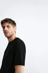 Jersey de punto color marrón oscuro, de corte relajado (relaxed fit), con cuello redondo y manga corta.