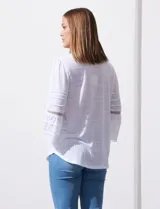 Blusa color celeste con escote en V, mangas largas acampanadas con detalle de crochet y frunces en los hombros.