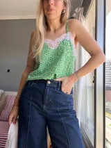 Top verde con estampado floral, breteles finos y detalle de encaje blanco en el escote.