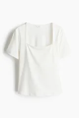 Remera blanca de punto suave con escote cuadrado y mangas cortas.