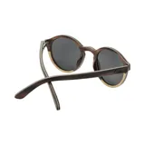 Lentes de sol con montura redonda de madera con detalles en marrón oscuro y claro.