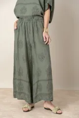 Pantalón palazzo de lino color crudo con estampado floral al tono, tiro alto y cintura elastizada.