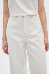 Pantalón jean de calce ancho y tiro alto, con diseño color block en tonos blanco y beige.