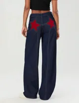 Pantalón de jean azul oscuro de pierna ancha con apliques de estrellas rojas en la parte trasera.