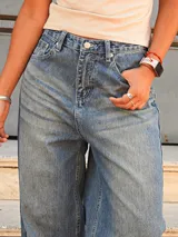 Jean azul de corte balloon, tiro medio, con un diseño de finas rayas verticales y lavado desgastado.