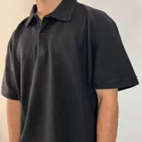 Chomba color crema con cuello polo, corte oversize y tejido acanalado vertical.