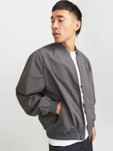 Campera bomber liviana color gris, de manga larga con cuello baseball y fit cómodo. Diseño con cierre frontal de cremallera, bolsillos delanteros funcionales y puños de canalé.