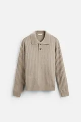 Sweater color beige de punto canalé con cuello polo, solapas amplias y cierre frontal con dos botones.