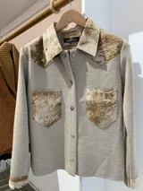 Camisa color beige de tejido de punto fino con apliques de cuero en cuello, hombros, bolsillos y puños.