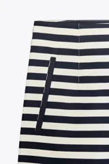 Bermuda de tiro alto con estampado de rayas horizontales en blanco y azul marino. Tiene bolsillos delanteros de vivo y cierre lateral con cremallera oculta en la costura.