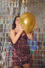 Vestido plateado con corte bajo el busto, abertura en la cintura y espalda descubierta. Se ata al cuello con dos tiras finas.