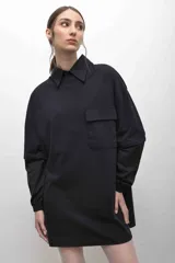 Remerón negro con cuello camisero, mangas largas con puños elásticos, bolsillo con tapa en el pecho y logo bordado.