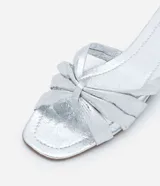 Sandalia plana mule metalizada con puntera cuadrada y tiras cruzadas con efecto crepitante.