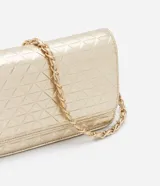 Bolso transversal pequeño color dorado, con correa de cadena y colgante redondo. Textura capitoneada, efecto metalizado y separador interior con cierre.