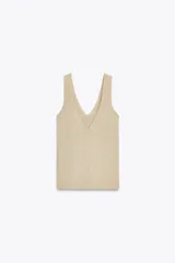 Top de punto color beige, con escote en pico y sisas anchas.
