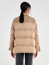 Chaqueta de diseño original con cuerpo en tejido de lana color beige y mangas tipo puffer acolchadas en tono camel. Presenta solapas de blazer, cierre frontal de dos botones y bolsillos de parche.