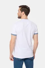 Remera de manga corta color azul grisáceo con cuello mao y tapeta de botones. Los puños de las mangas y el cuello son de color azul marino contrastante. Presenta un pequeño logo bordado en el pecho.