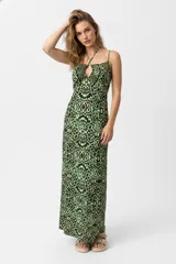 Vestido largo de poliéster con estampado abstracto en tonos verdes y negros. Tiene breteles finos que se cruzan en el frente y una abertura lateral.