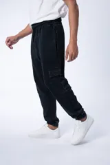 Pantalón cargo estilo jogger color gris oscuro con efecto lavado, bolsillos laterales con fuelle y cintura elástica con cordón ajustable.